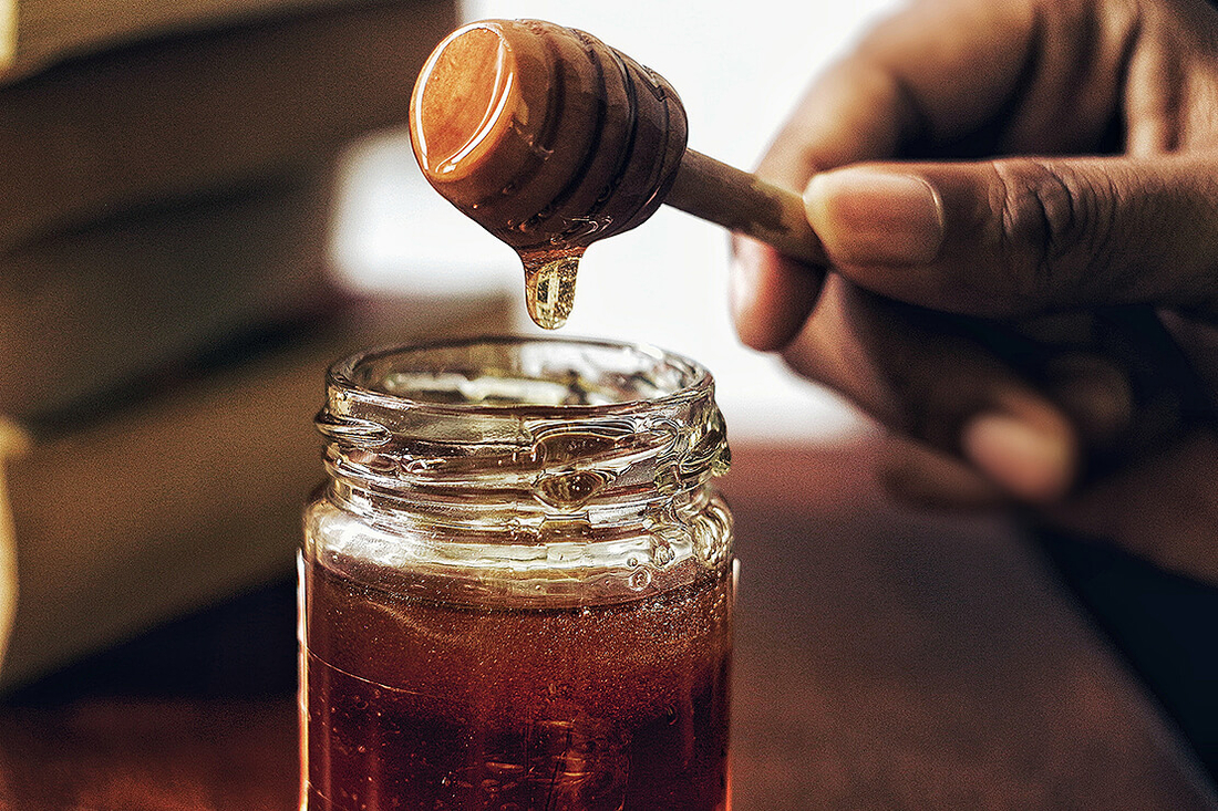 Photo by Arwin Neil Baichoo on Unsplash Honey running down dipper into jar of honey