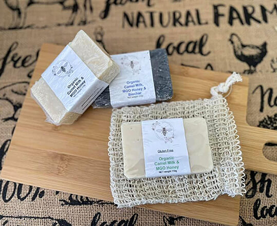 3 types of Goodwood Produce's MGO Honey & Camel milk bars of soap displayed on a chopping board