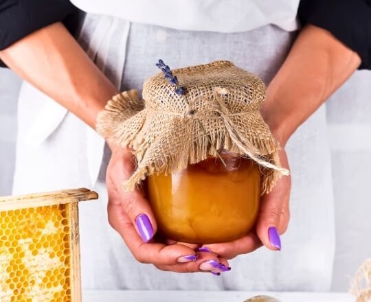 Women holding a jar of honey for hair