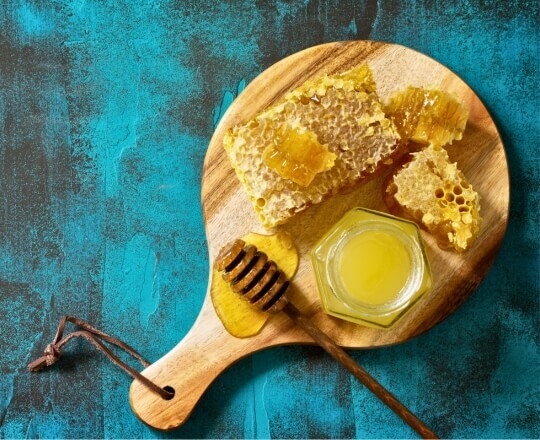 Honey on a board with a blue background